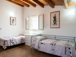 two beds in a room with white walls at Casa Delle Dune in Scicli