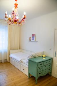 een slaapkamer met een bed en een kroonluchter bij Veľký 3-izbový apartmán Bratislava-Staré Mesto in Bratislava