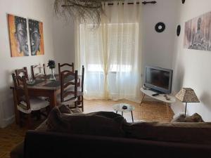 a living room with a couch and a table with a television at Encantador apartamento acogedor in Tarifa