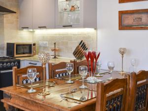 una cocina con una mesa de madera con copas de vino. en Borough Beck Cottage, en Helmsley
