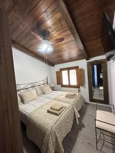 a bedroom with a large bed with a wooden ceiling at Villa rural de campo aldea Las Zorizas in Munera