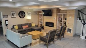 sala de estar con sofá, mesa y sillas en Country Inn & Suites by Radisson, McDonough, GA, en McDonough