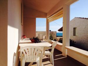 una mesa blanca y sillas en un balcón con vistas en Casa Delle Dune, en Scicli