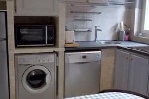 a kitchen with a washing machine and a microwave at Croisette Immo vieux port 6pièces 12 personnes in Cannes