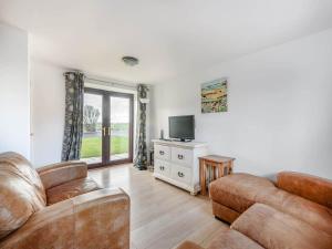 ein Wohnzimmer mit einem Sofa und einem TV in der Unterkunft Beautiful 3 Bedroom Cottage -Cottage 5 in Doncaster