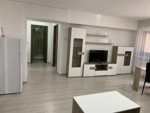 Elle comprend un salon doté d'un mobilier blanc et d'un réfrigérateur. dans l'établissement Cazare bloc nou ultracentral, à Râmnicu Vâlcea