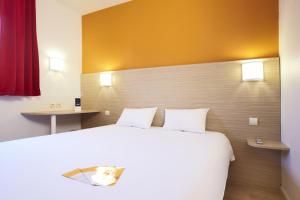 a bedroom with a large white bed and two tables at Premiere Classe Varsovie/Warszawa in Warsaw