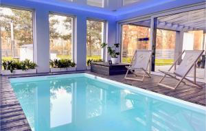 - une piscine dans une maison avec 2 chaises dans l'établissement Cozy Home In Niwy Ostroleckie With Jacuzzi, à Ostrołęka