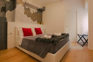 a bedroom with a large bed with red pillows at Regina di Verona - Royal Welcome in Verona
