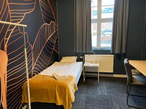 Mini-Hotel Borås Regementet في بوراس: غرفة نوم بسرير وبطانية صفراء