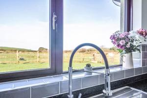 a kitchen counter with a sink and a window at Venn Down Lakes in Boscastle +10 photos