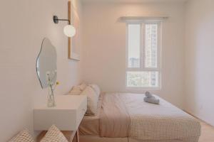 Habitación blanca con cama y espejo en NEW! Spacious French Verdi 10pax 3BR WonderfulView, en Cyberjaya
