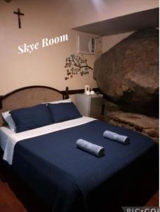 Pulangbato Falls Mountain Resort في دوماغيتي: غرفة نوم مع سرير مع منشفتين طويلتين عليه