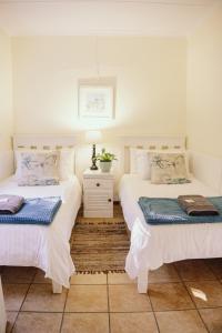 dwa łóżka siedzące obok siebie w pokoju w obiekcie Redberry Farm w mieście George