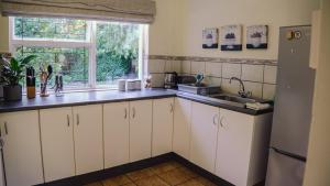 a kitchen with white cabinets and a sink and a window at Redberry Farm in George