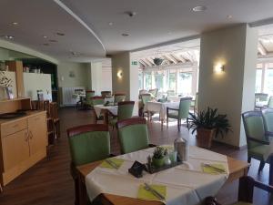 ein Esszimmer mit Tischen und Stühlen in einem Restaurant in der Unterkunft Savoy Hotel Bad Mergentheim in Bad Mergentheim