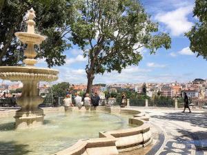 a fountain in a park with people sitting around it at Typical Portuguese Apartment in São Bento in Lisbon