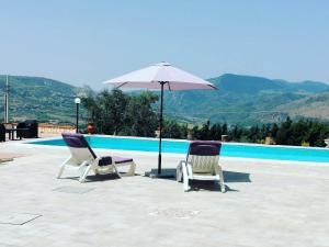 due sedie e un ombrellone accanto alla piscina di Villa Bella Vista a Palermo