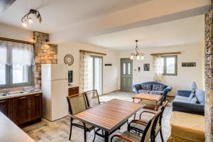 uma cozinha e sala de estar com mesa e cadeiras em Filistron Seaview Guesthouse -Tranquil Coastal Gem em Taktikoúpolis