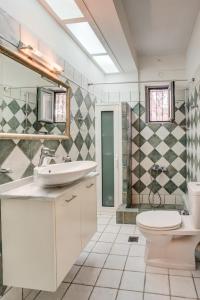 a bathroom with a sink and a toilet and a shower at Filistron Seaview Guesthouse -Tranquil Coastal Gem in Taktikoúpolis