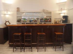 a bar with four stools in a room at Hôtel Beau Rivage in Le Lavandou