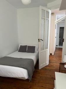 a bedroom with a bed and an open door at Hostal San Pelayo in Santiago de Compostela