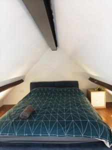 a bedroom with a green bed in a attic at Mezzanine style studio apartment 8 in London