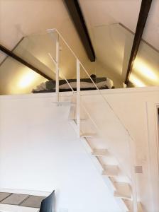 a white staircase in a room with a bed at Mezzanine style studio apartment 8 in London