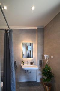 bagno con lavandino e specchio di Villas Thalia a Città di Zante