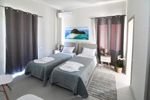 a bedroom with two beds and a table and chairs at Villas Thalia in Zakynthos