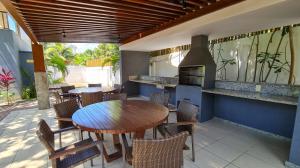 y cocina con mesa, sillas y fogones. en Imbassaí Village Solaris, en Imbassai