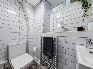 a white bathroom with a toilet and a sink at 1 King Street Accommodation in Delph