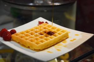a plate with a waffle with berries on it at Hotel Eurorest in Conegliano