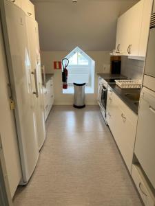 a kitchen with a white refrigerator and a sink at Mini-Hotel Borås Regementet in Borås
