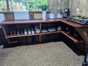 einem Holztisch mit Tellern und Geräten darauf in der Unterkunft Citronela Lodge Corcovado in Drake