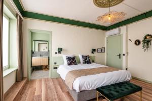 WatervlietにあるBoutique hotel Siesの緑の壁のベッドルーム1室(大型ベッド1台付)