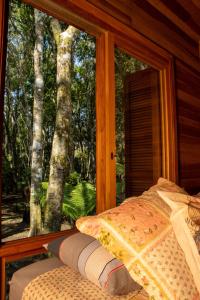 サン・フランシスコ・デ・パウラにあるMorada do Xaxim - Chalé Hortênciaのベッドルーム1室(木々の景色を望む窓付)