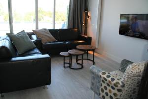 a living room with couches and a table and chairs at Schorrebloem 2 in Nieuwvliet