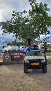 a group of people sitting on top of a car at Bagamoyo Home Stay in Bagamoyo
