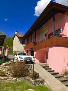 un coche aparcado frente a una casa rosa en La tana alla Costa di Sessa, en Sessa