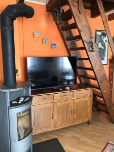 sala de estar con TV grande y escalera en La tana alla Costa di Sessa, en Sessa