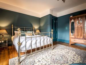 a bedroom with a bed and a blue wall at Pass the Keys Characterful period home in heart of Chagford in Chagford