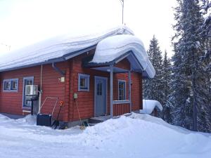 una pequeña cabaña roja con nieve encima en Kärpänpesä B en Syöte