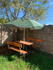a table and two benches under an umbrella at Casa de la Ribera Rengo in Valdivia
