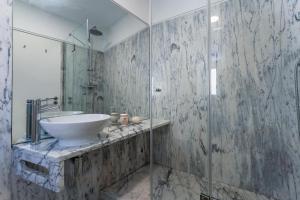 een badkamer met een wastafel en een glazen douche bij Town House Olhão 11 in Olhão