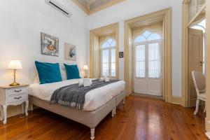 een slaapkamer met een groot bed met blauwe kussens bij Town House Olhão 11 in Olhão