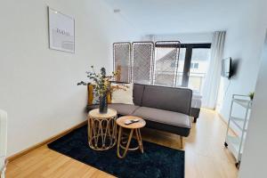 ein Wohnzimmer mit einem Sofa und einem Tisch in der Unterkunft Bright Studio - Central - Balcony - Trade Fair in Düsseldorf