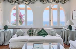 Sala de estar con sofá blanco y vistas al océano en Estate4home - Villa San Montano, en Massa Lubrense