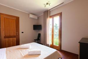 a bedroom with a bed with two towels on it at Appartamenti Le Maree in La Maddalena