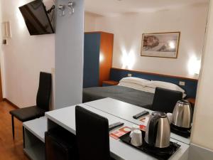 Kleines Zimmer mit einem Bett und einem Schreibtisch mit einem Tisch. in der Unterkunft Hotel Julia in Rom